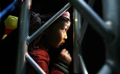 Matthew Lê, 8 tuổi, học sinh của trường Tiểu học Việt Nam Văn Lang nhìn màn trình diễn mừng năm mới Canh Dần tại Seattle Center House qua khe cửa.