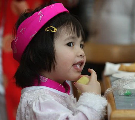 Vivian, 3 tuổi, được cha mẹ cho mặc áo dài khăn đóng đến vui tết