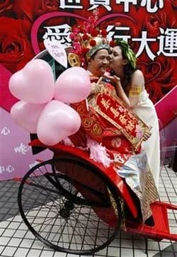 Thần tài nhận nụ hôn tại một khu mua sắm ở Hongkong. Năm nay, mùng 1 Tết trùng với Lễ Tình yêu (Ảnh AP)