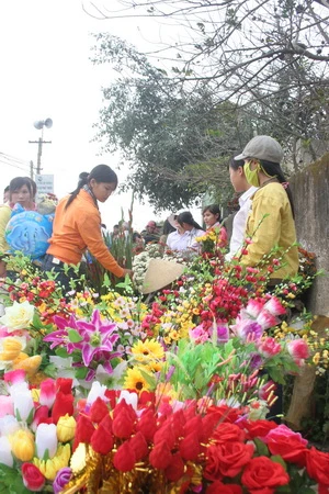 Hoa giấy được mua về trưng trên bàn thờ tổ tiên - Ảnh: N. Đông