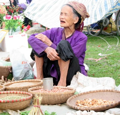 Với một vài cân tỏi, đậu phộng, cau khô…, bà cụ đến chợ với ước mong gặp mua may bán đắt trong năm mới - Ảnh: N. Đông