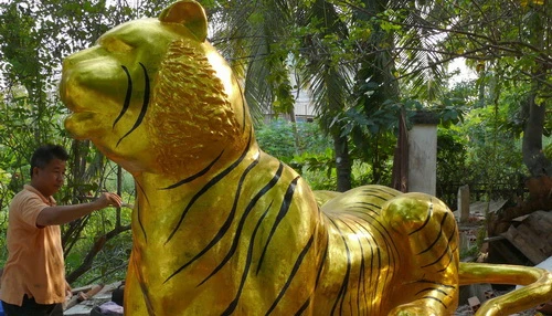 Nguyễn Minh Phương đang hoàn tất những chi tiết cuối của con hổ lớn nhất - dài 3m - sẽ đến với đường hoa Tết Canh Dần - Ảnh: Đăng Nguyên