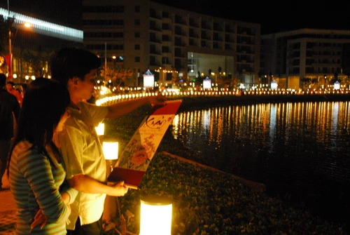 Khu vực hồ Bán Nguyệt tại Phú Mỹ Hưng (Q.7) với không gian đầy sắc xuân. Cầu hồ Bán Nguyệt lung linh trong đêm với nhiều màu sắc bằng nghệ thuật chạy sáng trên thành cầu