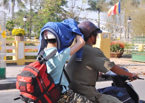 Mũ bảo hiểm cũng không che được nắng nóng. Ảnh chụp trên đường Lê Lợi - Huế 15g ngày 28 tết