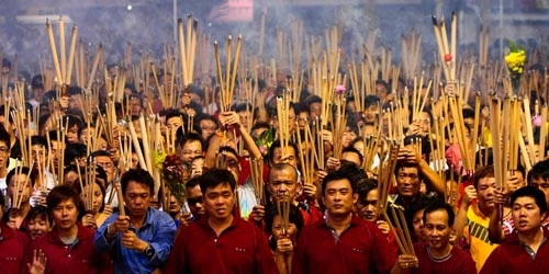 Sau giao thừa, người dân Singapore (đi trước Việt Nam một tiếng) đổ đến Kwan Im Thong Hood Cho để cầu may mắn năm mới - Ảnh: Reuters