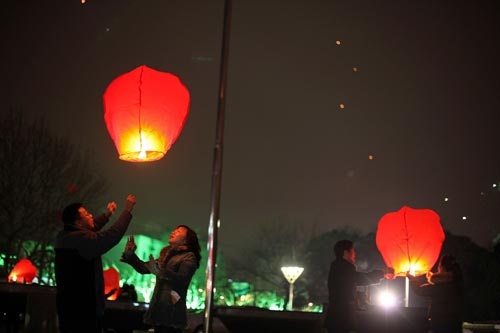 Người dân tại Thượng Hải, Trung Quốc (đi trước Việt Nam một tiếng) đang thả đèn lồng trong đêm giao thừa - Ảnh: Reuters Một công nhân tại Thượng Hải, Trung Quốc cầu an lành cho năm ngoái - Reuters