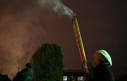 Người dân tại Thượng Hải, Trung Quốc (đi trước Việt Nam một tiếng) đang thả đèn lồng trong đêm giao thừa - Ảnh: Reuters Một công nhân tại Thượng Hải, Trung Quốc cầu an lành cho năm ngoái - Reuters