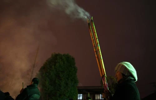 Người dân tại Thượng Hải, Trung Quốc (đi trước Việt Nam một tiếng) đang thả đèn lồng trong đêm giao thừa - Ảnh: Reuters Một công nhân tại Thượng Hải, Trung Quốc cầu an lành cho năm ngoái - Reuters