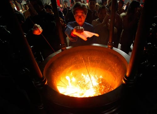 Một người dân Đài Loang đốt đèn và nhang tại đền Xingtian - Ảnh: Reuters