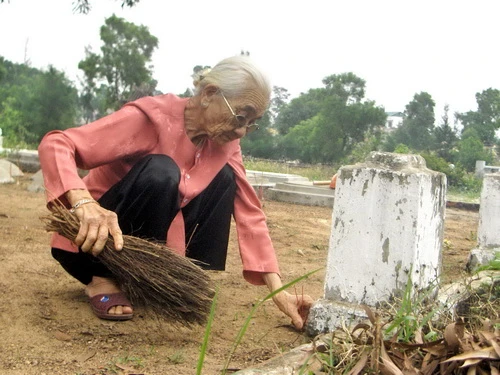Mẹ Việt Nam anh hùng Hà Thị Viễn đang dọn dẹp một mộ phần trong ngày mùng một tết