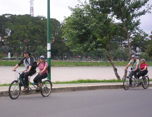 Du khách đạp xe đạp đôi quanh bờ hồ Xuân Hương. Ảnh: Nhất Hùng