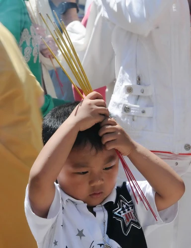 Một cậu bé cùng gia đình đi chùa đầu năm và khấn vái xem ra rất thành tâm (ảnh chụp tại Việt Nam Quốc Tự) - Ảnh: Minh Đức