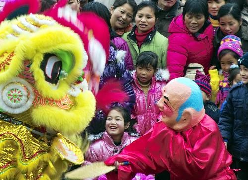 People watch lion dance performance on a street in Guilin, southwest China’s Guangxi Zhuang Autonomous Region, Feb. 14, 2010. Folk performance celebrating the Spring Festival attracted many local residents on Sunday