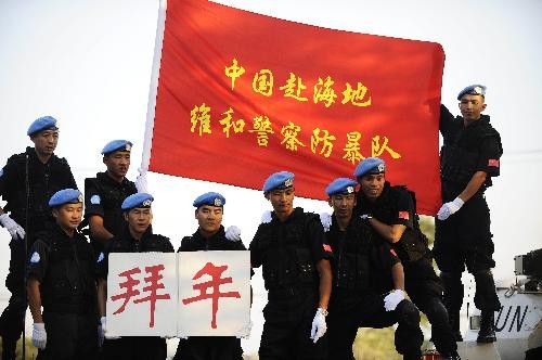 Chinese peacekeeping anti-riot police officers pose for a group photo to send new year’s greetings to their motherland, at the encampment of the Chinese peacekeeping anti-riot police team in Port-au-Prince, capital of Haiti, Feb. 6, 2010. According to Chinese Lunar calendar, this Saturday is the 23rd of the twelfth lunar month, marking the end of the year and the start of a series of Spring Festival activities in China.