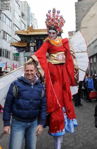 A Dutch man poses for a picture with a stilt performer during a celebration for the Chinese Spring Festival, or lunar New Year, in the Hague of the Netherlands, on Feb. 13, 2010