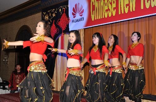 Employees of Huawei Technologies UAE branch dance during a party to celebrate the Chinese Lunar New Year in Abu Dhabi, capital of United Arab Emirates, Feb. 11, 2010.
