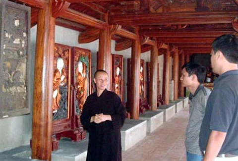 Sư thầy trụ trì chùa Trăm Gian đang kể lại những bức tranh cổ. Ảnh: ANTĐ.