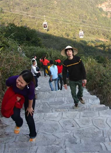 Nhà ga cáp treo được xây dựng theo lối cổ. Hát chèo tại sân nhà ga. Xếp hàng đợi đến lượt đi cáp treo. Hệ thống cáp treo hiện đại ở Yên Tử được chia làm 2 chặng. Chặng 1 từ dưới chân chùa Giải Oan cho đến gần chùa Hoa Yên. Chặng 2 từ chùa Hoa Yên lên gần tới chân chùa Đồng. Cáp treo lượn trên những ngọn cây, trong cảnh núi rừng và sương mờ ảo. Đoạn dốc lên chùa Hoa Yên nườm nượp khách thập phương. Không đi cáp treo, nhiều cụ già chống gậy leo bộ lên tới chùa Đồng. Tuy nhiên, đường xa khiến nhiều thanh niên cũng phải chùn chân, mỏi gối. Càng lên gần đỉnh núi, lượng người ngồi nghỉ lấy sức càng nhiều. Một em bé ngồi đổi tiền lẻ ngay dưới chân tháp. Tháp tổ thờ vua Trần Nhân Tông - người tạo dựng nên dòng Thiền Trúc Lâm. Tòa tháp cao 7 tầng mới được xây dựng ngay phía trên nhà ga cáp treo gần chùa Đồng. Chùa Đồng trên đỉnh núi thiêng Yên Tử cao hơn 1.000 mét. Du khách chen chân ở chùa Đồng để cầu khấn cho một năm an khang thịnh vượng. Rất nhiều người cầm tiền xoa lên thành chùa với ý nguyện cầu tài lộc. Phút thành tâm... Đã gần 20h, nhưng hai người công nhân vẫn đứng đốt cho hết số vàng mã trong ngày.