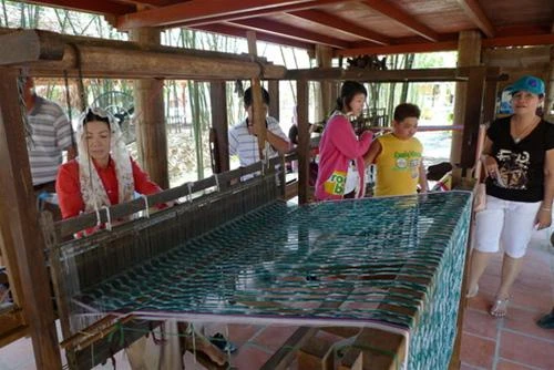 Khách du lịch tham quan nghề dệt thổ cẩm của đồng bào Chăm (ảnh chụp sáng mùng 3 tết) - Ảnh: N.C.T