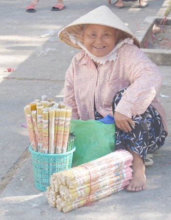 Bà cụ ngổi bán từ sáng sớm chưa được bó nhang nào. Bà cụ ngổi bán từ sáng sớm chưa được bó nhang nào.