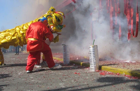 Ông địa nhảy múa trong tiếng pháo nổ đì đùng.