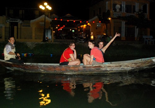 Du khách nước ngoài thích thú khi được đi xuồng ngắm đèn lồng lung linh trong đêm, thả hoa đăng trên trên sông Hoài.