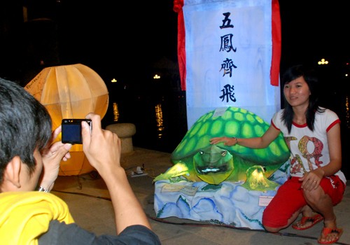 Các bạn trẻ chụp ảnh lưu niệm bên đèn lồng mô phỏng theo văn bia tiến sĩ ở Quốc Tử Giám(Hà Nội).