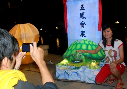 Các bạn trẻ chụp ảnh lưu niệm bên đèn lồng mô phỏng theo văn bia tiến sĩ ở Quốc Tử Giám(Hà Nội).