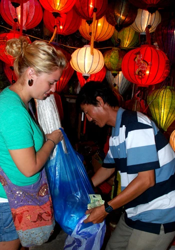 Du khách nước ngoài mua đèn lồng ở phố cổ Hội An về làm kỷ niệm.