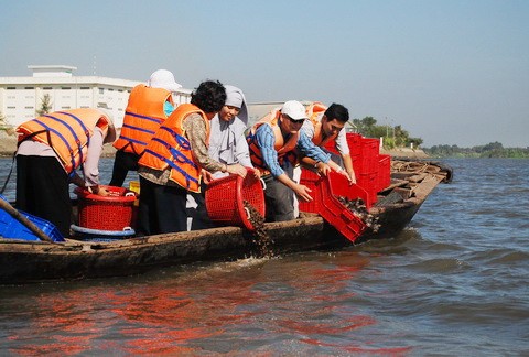 Du khách đổ cá, ốc xuống sông với hi vọng những sinh vật này sẽ tự do và người phóng sinh sẽ được phước lành - Ảnh: Mai Vinh Du khách đổ cá, ốc xuống sông với hi vọng những sinh vật này sẽ tự do và người phóng sinh sẽ được phước lành - Ảnh: Mai Vinh