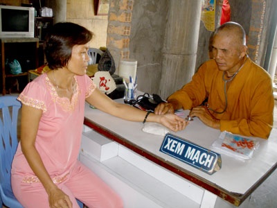 Sư ông Thích Minh Quang đang khám bệnh cho một bệnh nhân nghèo.