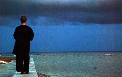 Một Sư cô đi dạo bên bờ biển khi cơn mưa sắp đổ lên đảo Sinh Tồn. Một Sư cô đi dạo bên bờ biển khi cơn mưa sắp đổ lên đảo Sinh Tồn.