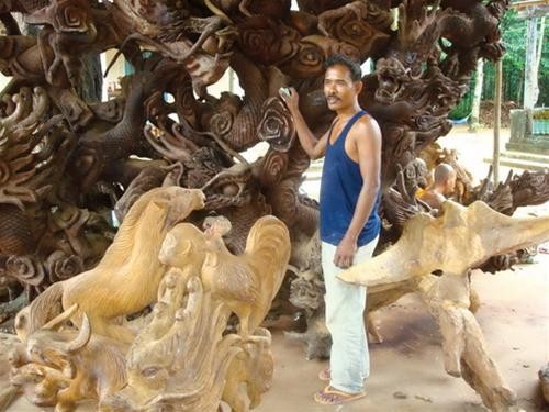 Nghệ nhân Thạch Buôl bên tác phẩm từ gốc rễ cây Nghệ nhân Thạch Buôl bên tác phẩm từ gốc rễ cây