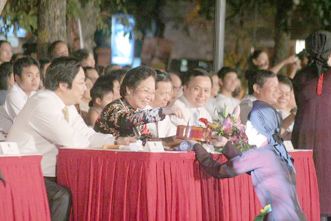 Các nghệ sĩ biểu diễn dân ca quan họ Bắc Ninh mời các vị đại biểu trầu têm cánh phượng - một nét văn hoá ẩm thực đẹp của Việt Nam.