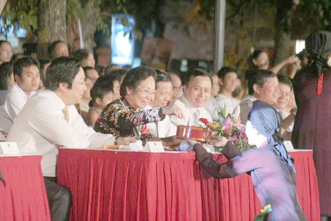 Các nghệ sĩ biểu diễn dân ca quan họ Bắc Ninh mời các vị đại biểu trầu têm cánh phượng - một nét văn hoá ẩm thực đẹp của Việt Nam.