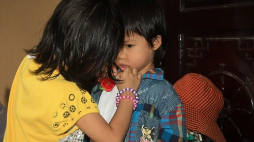 Hai chị em Tuyết Hồng và Tiểu Quyên cài bông hồng đỏ cho nhau