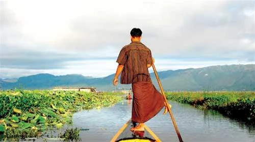 Người Intha mặc longyi và chèo thuyền bằng chân - Ảnh: Huỳnh Thu Dung