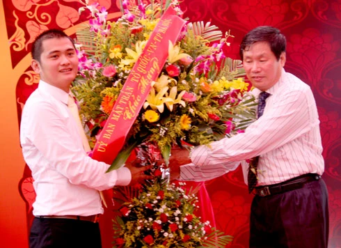 Ông Nguyễn Đoàn Anh Khoa nhận lẵng hoa chúc mừng của đại diện UBMT Tổ Quốc VN, sáng 30/9 tại Hà Nội trong lễ khai mạc triển lãm.