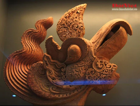 Những hiện vật này là ngói úp nóc có gắn lá đề trang trí rồng, phượng và tượng đầu rồng, đầu phượng... được dùng để gắn trên mái cung điện nhà Lý. Ở chính giữa mái cung điện là hình tượng lá đề lớn - biểu tượng của Phật giáo với đôi phượng chầu ở hai bên. Viên ngói gắn tượng đầu chim phượng này được dùng để trang trí đầu nóc mái cung điện. Theo tín ngưỡng dân gian, chim phượng một trong tứ linh (long, li, quy, phượng) và cũng là loài chim đẹp nhất trong số 360 loài chim. Đầu rồng thời Lý thống nhất ở kết cấu tạo hình: đầu nhỏ với miệng mở vờn một viên ngọc hay tinh tú đang xoay, răng nanh kéo dài xoắn với môi trên thành đường sống của chiếc mào có đường viền loăn xoăn như ngọn lửa đang bốc cao, phía trên mắt có những hoạ tiết hai đầu cuộn lại cùng chiều như số 3 ngửa và ngược chiều như hình chữ S, quanh mép có những lông măng và từ đó có một mảng kéo dài ra bốc lên lượn sóng làm bờm tóc. Hiện vật ở trên cũng là một viên ngói trang trí nóc mái. Ở hai bên của hình tượng lá đề lớn (nằm chính giữa nóc mái cung điện) là hai hàng ngói gắn lá đề lệch có trang trí rồng hoặc phượng. Tuy kích thước nhỏ nhưng những viên ngói này cũng được chạm khắc rất tỉ mỉ. Trong ảnh là ngói gắn lá đề lệch trang trí hình rồng. Còn đây là ngói gắn lá đề lệch trang trí hình chim phượng. Ngói ống lợp diềm mái gắn lá đề trang trí rồng (hoặc phượng) là loại ngói độc đáo nhất trong khu vực châu Á, mang bản sắc riêng của nghệ thuật kiến trúc cổ Việt Nam. Các di tích kinh đô cổ của các nước trong khu vực không có loại ngói ống cầu kỳ như thế này mà chỉ lợp ngói ống có đầu trang trí linh thú hay hoa sen, hoa cúc. Để thực hiện một lá đề gắn phượng (như trong ảnh), 40 nghệ nhân thời Lý phải thay phiên nhau chạm khắc trong hai ngày. Đến phiên của mình, mỗi nghệ nhân chỉ được phép thực hiện công việc trong khoảng 10 phút để đảm bảo sự tập trung cao độ nhất cho tác phẩm... Những hiện vật này là ngói úp nóc tạo hình cổ rồng. Không chỉ tượng trưng cho quyền lực hoàng gia, rồng thời Lý còn tượng trưng cho nguồn nước, nguồn sống của các cư dân trồng lúa. Những mảnh vỡ này thuộc về các hình tượng trang trí bên thành bậc cung điện, gồm bàn chân linh vật sấu thần và một đoạn thân rồng. Đầu máng nước tạo hình đầu sư tử (trên) và một mảnh ngói úp nóc gắn tượng chim uyên ương tuyệt đẹp, minh chứng khác cho trình độ thẩm mỹ rất cao của người thời Lý. Gạch vuông trang trí hoa sen (trên) và gạch vuông trang trí hoa cúc dây (dưới) là loại gạch có độ dày từ 8-15cm, dùng để lát nền cung điện. Hoa văn trang trí trên gạch cũng thế hiện ảnh hưởng sâu đậm của Phật giáo. Những viên gạch này ghi niên hiệu "Long Thụy thái bình tứ niên tạo", nghĩa là gạch được làm vào triều vua Lý thứ 3 - tức Lý Thánh Tông (1054 - 1072), niên hiệu Long Thuỵ Thái Bình thứ 4.