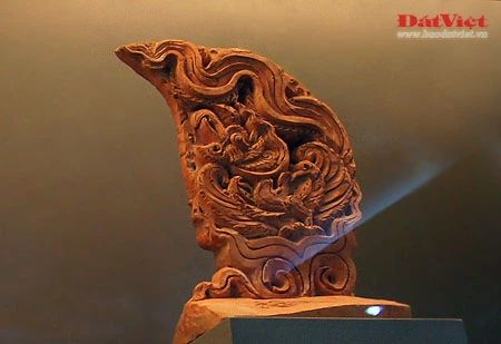 Những hiện vật này là ngói úp nóc có gắn lá đề trang trí rồng, phượng và tượng đầu rồng, đầu phượng... được dùng để gắn trên mái cung điện nhà Lý. Ở chính giữa mái cung điện là hình tượng lá đề lớn - biểu tượng của Phật giáo với đôi phượng chầu ở hai bên. Viên ngói gắn tượng đầu chim phượng này được dùng để trang trí đầu nóc mái cung điện. Theo tín ngưỡng dân gian, chim phượng một trong tứ linh (long, li, quy, phượng) và cũng là loài chim đẹp nhất trong số 360 loài chim. Đầu rồng thời Lý thống nhất ở kết cấu tạo hình: đầu nhỏ với miệng mở vờn một viên ngọc hay tinh tú đang xoay, răng nanh kéo dài xoắn với môi trên thành đường sống của chiếc mào có đường viền loăn xoăn như ngọn lửa đang bốc cao, phía trên mắt có những hoạ tiết hai đầu cuộn lại cùng chiều như số 3 ngửa và ngược chiều như hình chữ S, quanh mép có những lông măng và từ đó có một mảng kéo dài ra bốc lên lượn sóng làm bờm tóc. Hiện vật ở trên cũng là một viên ngói trang trí nóc mái. Ở hai bên của hình tượng lá đề lớn (nằm chính giữa nóc mái cung điện) là hai hàng ngói gắn lá đề lệch có trang trí rồng hoặc phượng. Tuy kích thước nhỏ nhưng những viên ngói này cũng được chạm khắc rất tỉ mỉ. Trong ảnh là ngói gắn lá đề lệch trang trí hình rồng. Còn đây là ngói gắn lá đề lệch trang trí hình chim phượng. Ngói ống lợp diềm mái gắn lá đề trang trí rồng (hoặc phượng) là loại ngói độc đáo nhất trong khu vực châu Á, mang bản sắc riêng của nghệ thuật kiến trúc cổ Việt Nam. Các di tích kinh đô cổ của các nước trong khu vực không có loại ngói ống cầu kỳ như thế này mà chỉ lợp ngói ống có đầu trang trí linh thú hay hoa sen, hoa cúc. Để thực hiện một lá đề gắn phượng (như trong ảnh), 40 nghệ nhân thời Lý phải thay phiên nhau chạm khắc trong hai ngày. Đến phiên của mình, mỗi nghệ nhân chỉ được phép thực hiện công việc trong khoảng 10 phút để đảm bảo sự tập trung cao độ nhất cho tác phẩm... Những hiện vật này là ngói úp nóc tạo hình cổ rồng. Không chỉ tượng trưng cho quyền lực hoàng gia, rồng thời Lý còn tượng trưng cho nguồn nước, nguồn sống của các cư dân trồng lúa. Những mảnh vỡ này thuộc về các hình tượng trang trí bên thành bậc cung điện, gồm bàn chân linh vật sấu thần và một đoạn thân rồng. Đầu máng nước tạo hình đầu sư tử (trên) và một mảnh ngói úp nóc gắn tượng chim uyên ương tuyệt đẹp, minh chứng khác cho trình độ thẩm mỹ rất cao của người thời Lý. Gạch vuông trang trí hoa sen (trên) và gạch vuông trang trí hoa cúc dây (dưới) là loại gạch có độ dày từ 8-15cm, dùng để lát nền cung điện. Hoa văn trang trí trên gạch cũng thế hiện ảnh hưởng sâu đậm của Phật giáo. Những viên gạch này ghi niên hiệu "Long Thụy thái bình tứ niên tạo", nghĩa là gạch được làm vào triều vua Lý thứ 3 - tức Lý Thánh Tông (1054 - 1072), niên hiệu Long Thuỵ Thái Bình thứ 4.