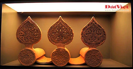 Những hiện vật này là ngói úp nóc có gắn lá đề trang trí rồng, phượng và tượng đầu rồng, đầu phượng... được dùng để gắn trên mái cung điện nhà Lý. Ở chính giữa mái cung điện là hình tượng lá đề lớn - biểu tượng của Phật giáo với đôi phượng chầu ở hai bên. Viên ngói gắn tượng đầu chim phượng này được dùng để trang trí đầu nóc mái cung điện. Theo tín ngưỡng dân gian, chim phượng một trong tứ linh (long, li, quy, phượng) và cũng là loài chim đẹp nhất trong số 360 loài chim. Đầu rồng thời Lý thống nhất ở kết cấu tạo hình: đầu nhỏ với miệng mở vờn một viên ngọc hay tinh tú đang xoay, răng nanh kéo dài xoắn với môi trên thành đường sống của chiếc mào có đường viền loăn xoăn như ngọn lửa đang bốc cao, phía trên mắt có những hoạ tiết hai đầu cuộn lại cùng chiều như số 3 ngửa và ngược chiều như hình chữ S, quanh mép có những lông măng và từ đó có một mảng kéo dài ra bốc lên lượn sóng làm bờm tóc. Hiện vật ở trên cũng là một viên ngói trang trí nóc mái. Ở hai bên của hình tượng lá đề lớn (nằm chính giữa nóc mái cung điện) là hai hàng ngói gắn lá đề lệch có trang trí rồng hoặc phượng. Tuy kích thước nhỏ nhưng những viên ngói này cũng được chạm khắc rất tỉ mỉ. Trong ảnh là ngói gắn lá đề lệch trang trí hình rồng. Còn đây là ngói gắn lá đề lệch trang trí hình chim phượng. Ngói ống lợp diềm mái gắn lá đề trang trí rồng (hoặc phượng) là loại ngói độc đáo nhất trong khu vực châu Á, mang bản sắc riêng của nghệ thuật kiến trúc cổ Việt Nam. Các di tích kinh đô cổ của các nước trong khu vực không có loại ngói ống cầu kỳ như thế này mà chỉ lợp ngói ống có đầu trang trí linh thú hay hoa sen, hoa cúc. Để thực hiện một lá đề gắn phượng (như trong ảnh), 40 nghệ nhân thời Lý phải thay phiên nhau chạm khắc trong hai ngày. Đến phiên của mình, mỗi nghệ nhân chỉ được phép thực hiện công việc trong khoảng 10 phút để đảm bảo sự tập trung cao độ nhất cho tác phẩm... Những hiện vật này là ngói úp nóc tạo hình cổ rồng. Không chỉ tượng trưng cho quyền lực hoàng gia, rồng thời Lý còn tượng trưng cho nguồn nước, nguồn sống của các cư dân trồng lúa. Những mảnh vỡ này thuộc về các hình tượng trang trí bên thành bậc cung điện, gồm bàn chân linh vật sấu thần và một đoạn thân rồng. Đầu máng nước tạo hình đầu sư tử (trên) và một mảnh ngói úp nóc gắn tượng chim uyên ương tuyệt đẹp, minh chứng khác cho trình độ thẩm mỹ rất cao của người thời Lý. Gạch vuông trang trí hoa sen (trên) và gạch vuông trang trí hoa cúc dây (dưới) là loại gạch có độ dày từ 8-15cm, dùng để lát nền cung điện. Hoa văn trang trí trên gạch cũng thế hiện ảnh hưởng sâu đậm của Phật giáo. Những viên gạch này ghi niên hiệu "Long Thụy thái bình tứ niên tạo", nghĩa là gạch được làm vào triều vua Lý thứ 3 - tức Lý Thánh Tông (1054 - 1072), niên hiệu Long Thuỵ Thái Bình thứ 4.