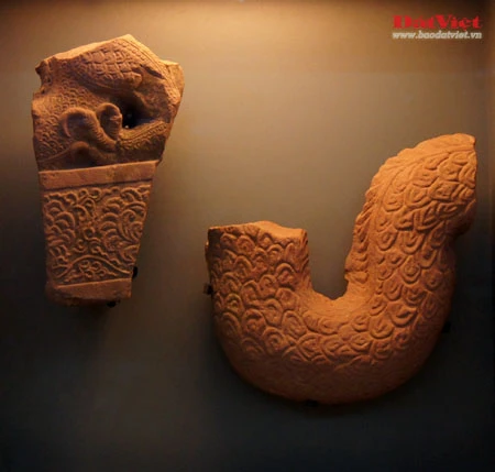 Những hiện vật này là ngói úp nóc có gắn lá đề trang trí rồng, phượng và tượng đầu rồng, đầu phượng... được dùng để gắn trên mái cung điện nhà Lý. Ở chính giữa mái cung điện là hình tượng lá đề lớn - biểu tượng của Phật giáo với đôi phượng chầu ở hai bên. Viên ngói gắn tượng đầu chim phượng này được dùng để trang trí đầu nóc mái cung điện. Theo tín ngưỡng dân gian, chim phượng một trong tứ linh (long, li, quy, phượng) và cũng là loài chim đẹp nhất trong số 360 loài chim. Đầu rồng thời Lý thống nhất ở kết cấu tạo hình: đầu nhỏ với miệng mở vờn một viên ngọc hay tinh tú đang xoay, răng nanh kéo dài xoắn với môi trên thành đường sống của chiếc mào có đường viền loăn xoăn như ngọn lửa đang bốc cao, phía trên mắt có những hoạ tiết hai đầu cuộn lại cùng chiều như số 3 ngửa và ngược chiều như hình chữ S, quanh mép có những lông măng và từ đó có một mảng kéo dài ra bốc lên lượn sóng làm bờm tóc. Hiện vật ở trên cũng là một viên ngói trang trí nóc mái. Ở hai bên của hình tượng lá đề lớn (nằm chính giữa nóc mái cung điện) là hai hàng ngói gắn lá đề lệch có trang trí rồng hoặc phượng. Tuy kích thước nhỏ nhưng những viên ngói này cũng được chạm khắc rất tỉ mỉ. Trong ảnh là ngói gắn lá đề lệch trang trí hình rồng. Còn đây là ngói gắn lá đề lệch trang trí hình chim phượng. Ngói ống lợp diềm mái gắn lá đề trang trí rồng (hoặc phượng) là loại ngói độc đáo nhất trong khu vực châu Á, mang bản sắc riêng của nghệ thuật kiến trúc cổ Việt Nam. Các di tích kinh đô cổ của các nước trong khu vực không có loại ngói ống cầu kỳ như thế này mà chỉ lợp ngói ống có đầu trang trí linh thú hay hoa sen, hoa cúc. Để thực hiện một lá đề gắn phượng (như trong ảnh), 40 nghệ nhân thời Lý phải thay phiên nhau chạm khắc trong hai ngày. Đến phiên của mình, mỗi nghệ nhân chỉ được phép thực hiện công việc trong khoảng 10 phút để đảm bảo sự tập trung cao độ nhất cho tác phẩm... Những hiện vật này là ngói úp nóc tạo hình cổ rồng. Không chỉ tượng trưng cho quyền lực hoàng gia, rồng thời Lý còn tượng trưng cho nguồn nước, nguồn sống của các cư dân trồng lúa. Những mảnh vỡ này thuộc về các hình tượng trang trí bên thành bậc cung điện, gồm bàn chân linh vật sấu thần và một đoạn thân rồng. Đầu máng nước tạo hình đầu sư tử (trên) và một mảnh ngói úp nóc gắn tượng chim uyên ương tuyệt đẹp, minh chứng khác cho trình độ thẩm mỹ rất cao của người thời Lý. Gạch vuông trang trí hoa sen (trên) và gạch vuông trang trí hoa cúc dây (dưới) là loại gạch có độ dày từ 8-15cm, dùng để lát nền cung điện. Hoa văn trang trí trên gạch cũng thế hiện ảnh hưởng sâu đậm của Phật giáo. Những viên gạch này ghi niên hiệu "Long Thụy thái bình tứ niên tạo", nghĩa là gạch được làm vào triều vua Lý thứ 3 - tức Lý Thánh Tông (1054 - 1072), niên hiệu Long Thuỵ Thái Bình thứ 4.