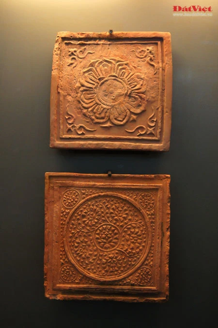 Những hiện vật này là ngói úp nóc có gắn lá đề trang trí rồng, phượng và tượng đầu rồng, đầu phượng... được dùng để gắn trên mái cung điện nhà Lý. Ở chính giữa mái cung điện là hình tượng lá đề lớn - biểu tượng của Phật giáo với đôi phượng chầu ở hai bên. Viên ngói gắn tượng đầu chim phượng này được dùng để trang trí đầu nóc mái cung điện. Theo tín ngưỡng dân gian, chim phượng một trong tứ linh (long, li, quy, phượng) và cũng là loài chim đẹp nhất trong số 360 loài chim. Đầu rồng thời Lý thống nhất ở kết cấu tạo hình: đầu nhỏ với miệng mở vờn một viên ngọc hay tinh tú đang xoay, răng nanh kéo dài xoắn với môi trên thành đường sống của chiếc mào có đường viền loăn xoăn như ngọn lửa đang bốc cao, phía trên mắt có những hoạ tiết hai đầu cuộn lại cùng chiều như số 3 ngửa và ngược chiều như hình chữ S, quanh mép có những lông măng và từ đó có một mảng kéo dài ra bốc lên lượn sóng làm bờm tóc. Hiện vật ở trên cũng là một viên ngói trang trí nóc mái. Ở hai bên của hình tượng lá đề lớn (nằm chính giữa nóc mái cung điện) là hai hàng ngói gắn lá đề lệch có trang trí rồng hoặc phượng. Tuy kích thước nhỏ nhưng những viên ngói này cũng được chạm khắc rất tỉ mỉ. Trong ảnh là ngói gắn lá đề lệch trang trí hình rồng. Còn đây là ngói gắn lá đề lệch trang trí hình chim phượng. Ngói ống lợp diềm mái gắn lá đề trang trí rồng (hoặc phượng) là loại ngói độc đáo nhất trong khu vực châu Á, mang bản sắc riêng của nghệ thuật kiến trúc cổ Việt Nam. Các di tích kinh đô cổ của các nước trong khu vực không có loại ngói ống cầu kỳ như thế này mà chỉ lợp ngói ống có đầu trang trí linh thú hay hoa sen, hoa cúc. Để thực hiện một lá đề gắn phượng (như trong ảnh), 40 nghệ nhân thời Lý phải thay phiên nhau chạm khắc trong hai ngày. Đến phiên của mình, mỗi nghệ nhân chỉ được phép thực hiện công việc trong khoảng 10 phút để đảm bảo sự tập trung cao độ nhất cho tác phẩm... Những hiện vật này là ngói úp nóc tạo hình cổ rồng. Không chỉ tượng trưng cho quyền lực hoàng gia, rồng thời Lý còn tượng trưng cho nguồn nước, nguồn sống của các cư dân trồng lúa. Những mảnh vỡ này thuộc về các hình tượng trang trí bên thành bậc cung điện, gồm bàn chân linh vật sấu thần và một đoạn thân rồng. Đầu máng nước tạo hình đầu sư tử (trên) và một mảnh ngói úp nóc gắn tượng chim uyên ương tuyệt đẹp, minh chứng khác cho trình độ thẩm mỹ rất cao của người thời Lý. Gạch vuông trang trí hoa sen (trên) và gạch vuông trang trí hoa cúc dây (dưới) là loại gạch có độ dày từ 8-15cm, dùng để lát nền cung điện. Hoa văn trang trí trên gạch cũng thế hiện ảnh hưởng sâu đậm của Phật giáo. Những viên gạch này ghi niên hiệu "Long Thụy thái bình tứ niên tạo", nghĩa là gạch được làm vào triều vua Lý thứ 3 - tức Lý Thánh Tông (1054 - 1072), niên hiệu Long Thuỵ Thái Bình thứ 4.