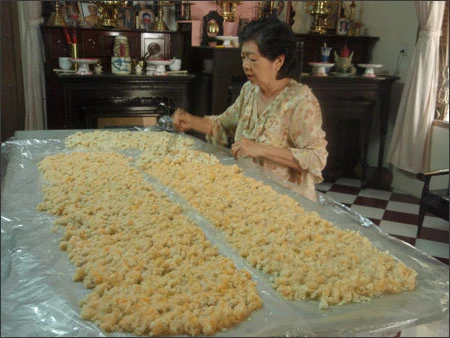 Cô Vân Loan đang dùng đũa đảo để mốc lên màu vàng đều Cô Vân Loan đang dùng đũa đảo để mốc lên màu vàng đều