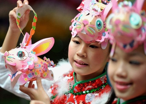 Các em thiếu nhi Đài Loan trang điểm và chơi đồ có hình ảnh đẹp đẽ của con vật tượng trưng cho năm mới.