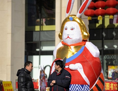 Vì thế Thỏ hiện diện khắp nơi khi Tết Nguyên đán gần kề. Trong ảnh, hai người đàn ông nói chuyện phía trước một hình nộm thỏ to tướng tại một trung tâm thương mại ở Bắc Kinh.