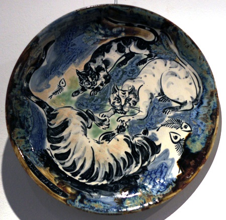 Hai chú mèo trong nét vẽ cách điệu quấn quít bên nhau trong tác phẩm "Tâm giao", thực hiện trên chất liệu gốm trắng men màu của nghệ sĩ Đặng Toàn Hưng. Hình tượng mèo thể hiện qua những hình khối vuông trong tác phẩm làm bằng sành trắng có tên Mèo cá của nghệ sĩ Nguyễn Mạnh Thẩm. Một chú mèo uốn mình trong tác phẩm sơn mài trên đĩa của tác giả Nguyễn Thanh Giang. Hai chú mèo tạo nên họa tiết cân xứng trên - dưới trong tác phẩm làm bằng sành nâu có tên Song mão của tác giả Nguyễn Mạnh Thẩm. Giấc mơ của một chú mèo được thể hiện trong tác phẩm của nghệ sĩ Nguyễn Duy Nghiêm. Chú mèo cuộn tròn tạo nên vẻ sinh động và ấm cúng trong bức tranh sơn mài có tên Đêm trăng của nghệ sĩ Đặng Vũ Đạt. Phải nhìn kỹ mới nhận ra có đến ba chú mèo trong tác phẩm "Đời thường" của tác giả Đặng Toàn Hưng. Những chú mèo trong tác phẩm Đĩa tam hợp của nghệ sĩ Lê Quang Chiến.