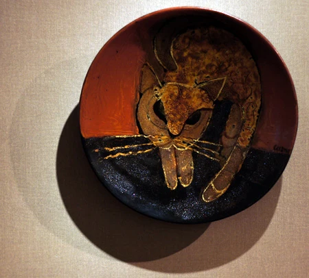 Hai chú mèo trong nét vẽ cách điệu quấn quít bên nhau trong tác phẩm "Tâm giao", thực hiện trên chất liệu gốm trắng men màu của nghệ sĩ Đặng Toàn Hưng. Hình tượng mèo thể hiện qua những hình khối vuông trong tác phẩm làm bằng sành trắng có tên Mèo cá của nghệ sĩ Nguyễn Mạnh Thẩm. Một chú mèo uốn mình trong tác phẩm sơn mài trên đĩa của tác giả Nguyễn Thanh Giang. Hai chú mèo tạo nên họa tiết cân xứng trên - dưới trong tác phẩm làm bằng sành nâu có tên Song mão của tác giả Nguyễn Mạnh Thẩm. Giấc mơ của một chú mèo được thể hiện trong tác phẩm của nghệ sĩ Nguyễn Duy Nghiêm. Chú mèo cuộn tròn tạo nên vẻ sinh động và ấm cúng trong bức tranh sơn mài có tên Đêm trăng của nghệ sĩ Đặng Vũ Đạt. Phải nhìn kỹ mới nhận ra có đến ba chú mèo trong tác phẩm "Đời thường" của tác giả Đặng Toàn Hưng. Những chú mèo trong tác phẩm Đĩa tam hợp của nghệ sĩ Lê Quang Chiến.