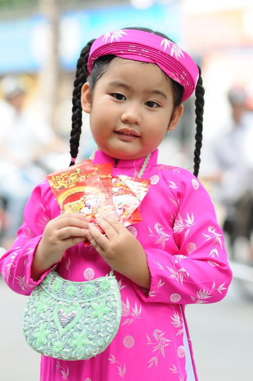 Các bé mặc áo dài, quấn khăn đống đi chúc Tết rất dễ thương. Mặc dù chưa hiểu hết được ý nghĩa của việc mặc áo dài truyền thống và những câu chúc tết nhưng các bé tỏ ra rất hào hứng trong trang phục mới. Đa dạng các kiểu áo dài cách tân dành cho các bé trong dịp Tết này. Tung tăng xuống phố. Và tạo dáng dễ thương Ngộ nghĩnh trẻ em áo dài, khăn đống chúc Tết
