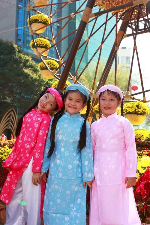 Các bé mặc áo dài, quấn khăn đống đi chúc Tết rất dễ thương. Mặc dù chưa hiểu hết được ý nghĩa của việc mặc áo dài truyền thống và những câu chúc tết nhưng các bé tỏ ra rất hào hứng trong trang phục mới. Đa dạng các kiểu áo dài cách tân dành cho các bé trong dịp Tết này. Tung tăng xuống phố. Và tạo dáng dễ thương Ngộ nghĩnh trẻ em áo dài, khăn đống chúc Tết